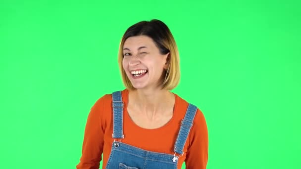 Lovely girl smiles broadly and winks. Green screen — Stock Video