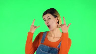 Kadın taş gibi bir jest yapıyor, hayattan zevk alıyor ve gülüyor. Yeşil Ekran