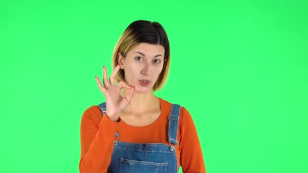 Smiling girl makes sign ok. Green screen — Stock Video