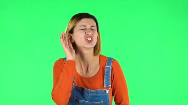 Woman holding hand near ear trying to listen to interesting news expressing communication concept. Green screen — 비디오