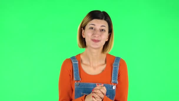 Girl keeps palm together and asks for something. Green screen — Stockvideo