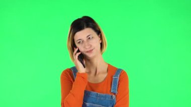 Woman speaking via telephone looking boredon. Green screen