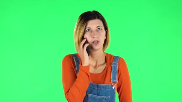 Девушка гневно говорит по телефону, что-то доказывает. Зеленый экран — стоковое видео