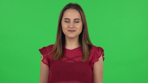 Portrait of tender girl in red dress is smiling while looking at camera. Green screen — Αρχείο Βίντεο