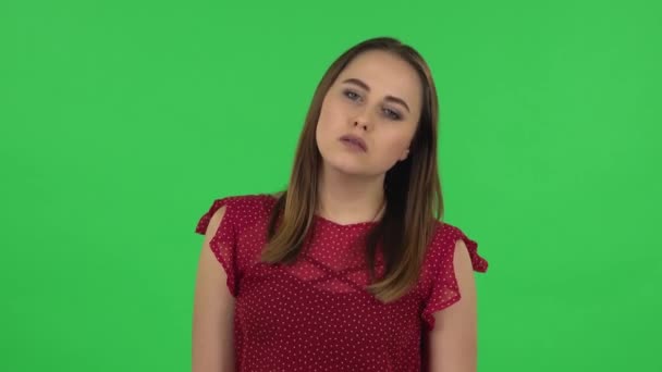Portrait of tender girl in red dress is upset and tired. Green screen — Stock video