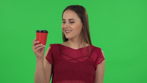 Portrait of tender girl in red dress is enjoying coffee. Green screen — Αρχείο Βίντεο