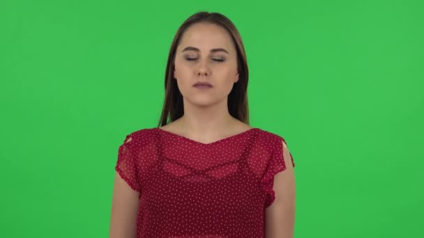 Portrait of tender girl carefully examines something then fearfully covers her face with her hand. Green screen — Stok video