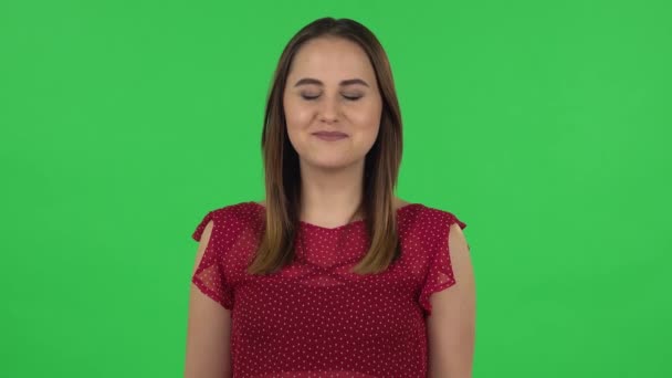 Портрет нежной девушки в красном платье с шокированным удивленным выражением лица. Зеленый экран — стоковое видео