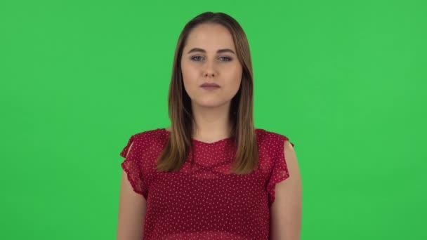 Портрет нежной девушки в красном платье говорит вау с шокированным выражением лица. Зеленый экран — стоковое видео