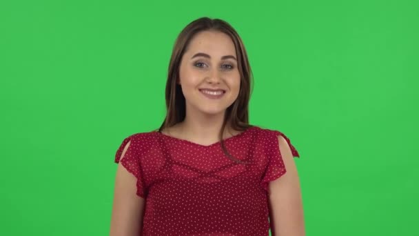 Portrait of tender girl in red dress communicates with someone in a friendly manner. Green screen — Stock video