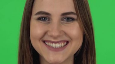 Female looking straight and smiling. Close up. Green screen