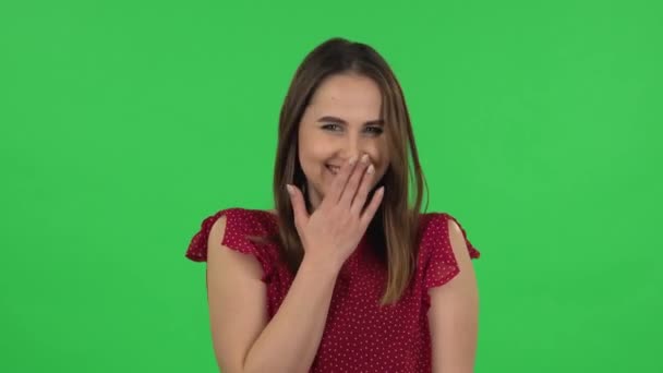 Portrait of tender girl in red dress is pointing herself, say who me no thanks i do not need and laughing. Green screen — ストック動画