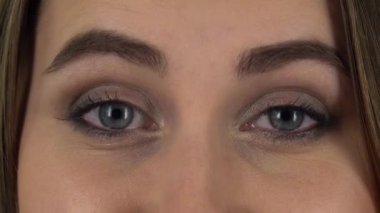 Woman looking straight, smiling and raises an eyebrow flirting. Close up