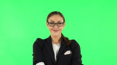 Woman smiling while looking at camera. Green screen