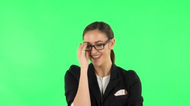 Woman laughing while looking at camera. Green screen