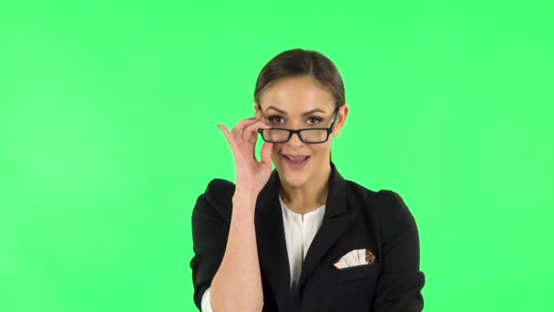 Woman coquettishly smiling and laughing while looking at camera. Green screen — Stok video