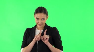 Sevimli kız gülümser, parmaklarıyla kalbini gösterir ve öpüşür. Yeşil Ekran