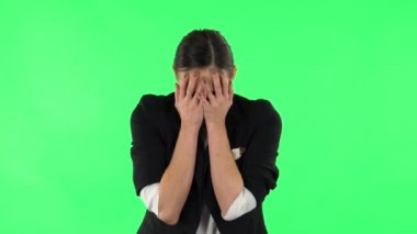 Kız bir şeyi dikkatlice inceler ve sonra korkunç bir şekilde eliyle yüzünü kapatır. Yeşil Ekran