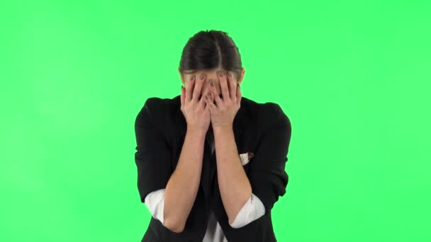 Girl carefully examines something then fearfully covers her face with her hand. Green screen — Stock Video