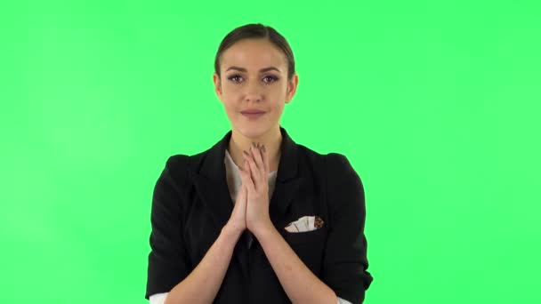 Tender girl with folded arms in front of her and tears in her eyes. Green screen — Stockvideo