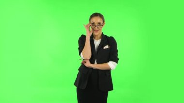 Woman coquettishly smiling and laughing while looking at camera. Green screen