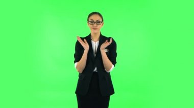 Girl claps her hands with dissatisfaction. Green screen