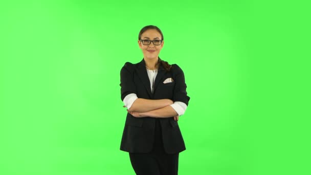 Woman smiling while looking at camera. Green screen — Stockvideo