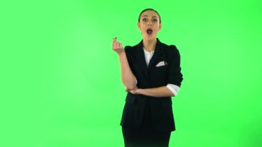 Sevimli kız gülümser, parmaklarıyla kalbini gösterir ve öpüşür. Yeşil Ekran