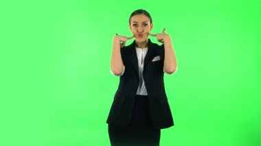 Trendy girl poses for camera makes funny faces. Green screen