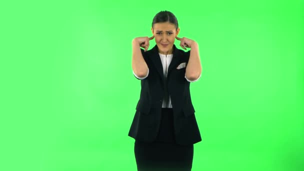 Girl covers her ears, too loud. Green screen — Stok video