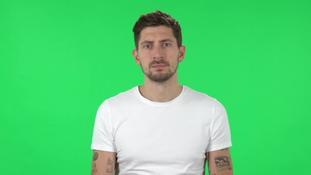 Portrait of confident guy is looking straight and crossing his arms over his chest. Green screen — Stock videók