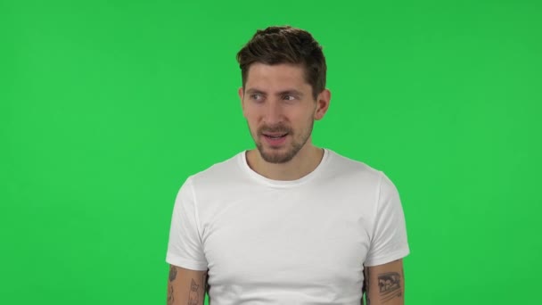 Portrait of confident guy is looking around and having fun. Green screen — Stock video