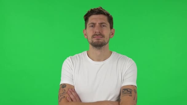 Portrait of confident guy is looking straight, crossing his arms over his chest and nodding his head. Green screen — Stock video