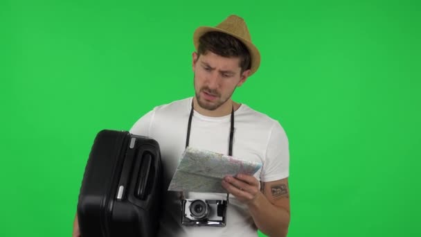 Portret turysty z walizką uważnie bada mapę, potem patrzy w kamerę i zszokowany mówiąc o mój Boże. Zielony ekran — Wideo stockowe