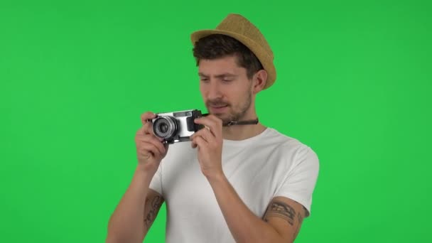 Retrato de turista en sombrero de vacaciones toma fotos en una cámara retro. Pantalla verde — Vídeos de Stock