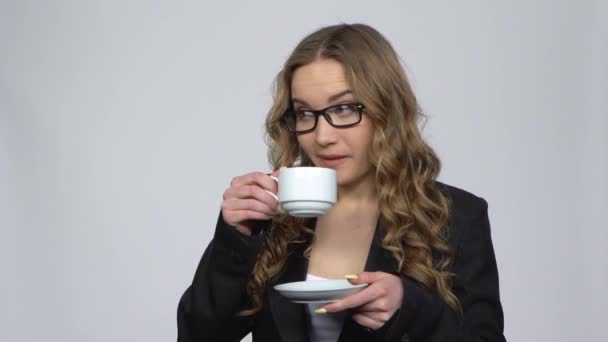 Офісна працівник жінка п'є каву і посміхається розмовляти з кимось — стокове відео
