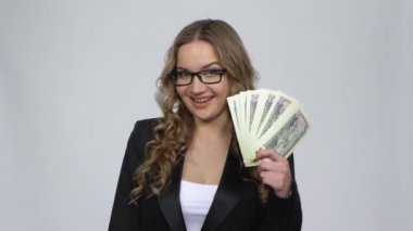 Kız nakit para tutuyor ve kredi kartı seçiyor. Onaylı bir şekilde onaylıyor.