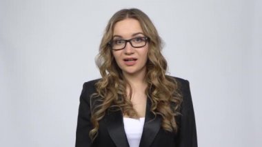 Gri arka planda hayal kırıklığı yaratan omuz silkerek para arayan bir kadın.