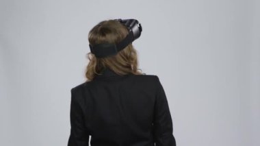 VR konsepti. Gri arka planda sanal gerçeklik gözlüklü kadın