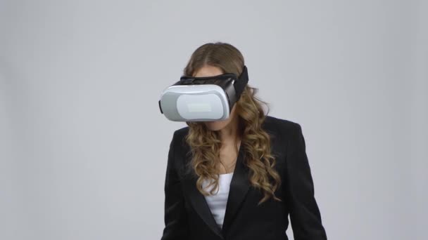 Femme avec des lunettes de réalité virtuelle sur fond gris — Video