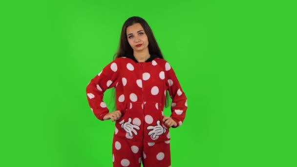 Mooi meisje in rode fleece pyjama klapt onverschillig in haar handen. Groen scherm — Stockvideo