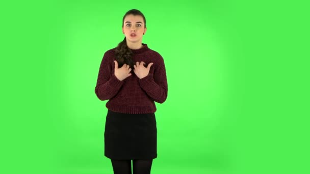 Girl looks at the camera with excitement, then sighs in relief and smiles, received pleasant information. Green screen — Stock Video