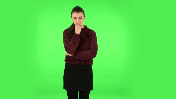 Mädchen untersucht etwas sorgfältig und bedeckt dann ängstlich ihr Gesicht mit der Hand. Green Screen im Studio — Stockvideo