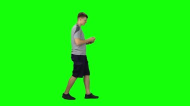 Gülümseyen adam gider ve telefonda mesaj atar, Chroma Key. Profil kenarı görünümü