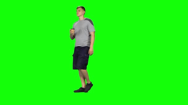 Male is walking and drinking coffee from a paper cup. Chroma Key — Stock Video