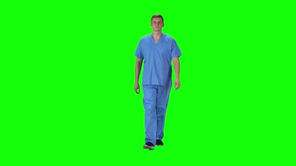 Medical man going and looking forward against a green background. Slow motion. — 비디오