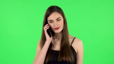Gülümseyen kız cep telefonu için konuşuyor ve seviniyor. Yeşil Ekran