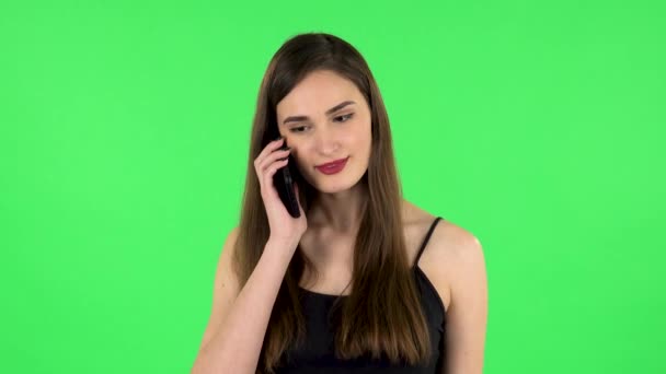 Lächelndes Mädchen, das nach dem Handy spricht und sich freut. Grüner Bildschirm — Stockvideo