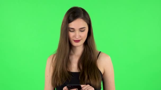 Flicka frågar efter information på nätverket via telefon på grön skärm — Stockvideo