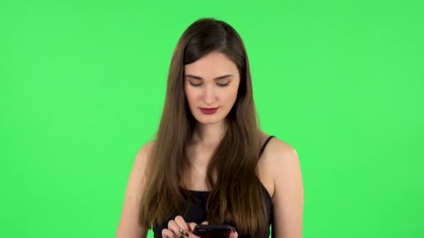 Ung kvinna sms:ar på sin telefon. Grön skärm — Stockvideo